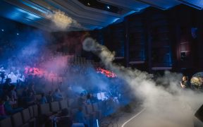 Während der DLR-Raumfahrt-Show zieht sich eine große Nebelwolke durch den Zuschauerraum der Lausitzhalle Hoyerswerda. Das Publikum verfolgt die Vorführung aufmerksam von den Sitzreihen aus.