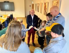 Oberbürgermeister Torsten Ruban-Zeh steht gemeinsam mit Kindern, Jugendlichen und Betreuern der Pfadfinderschaft in einem Kreis. Die Teilnehmenden reichen sich zur Verabschiedung die Hände.