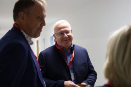 Bürgermeister Mirko Pink und Oberbürgermeister Torsten Ruban-Zeh stehen in einem Innenraum und sprechen mit einer weiteren Person.