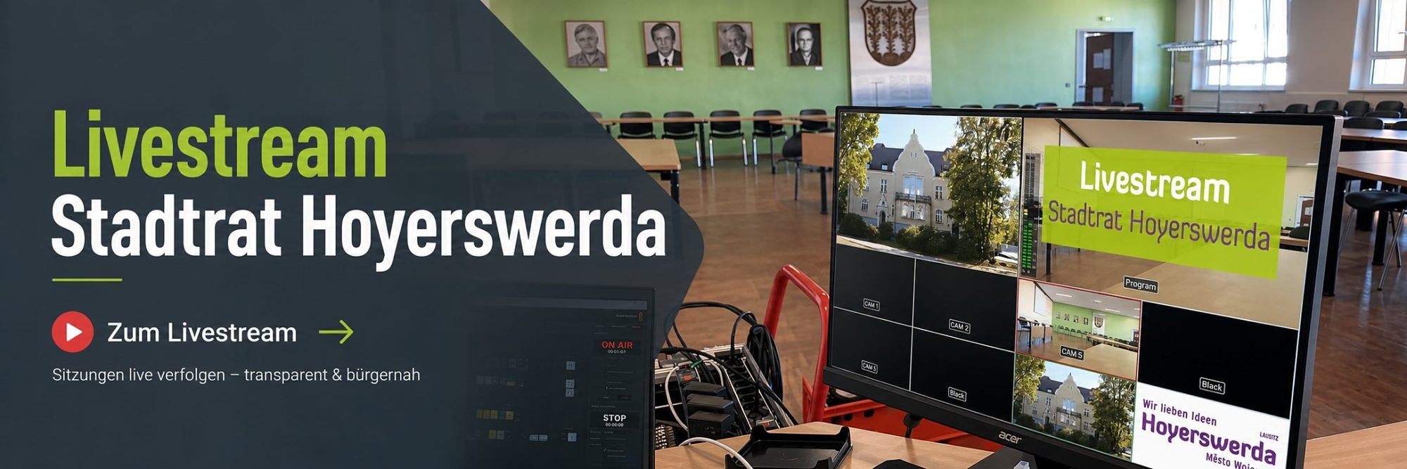 Banner mit dem Text „Livestream Stadtrat Hoyerswerda" und dem Button „Zum Livestream". Im Hintergrund der leere Sitzungssaal des Stadtrats mit Porträts früherer Oberbürgermeister an der Wand sowie ein Regiemonitor mit mehreren Kamerabildern, der Übertragungstechnik und dem Livestream-Overlay.